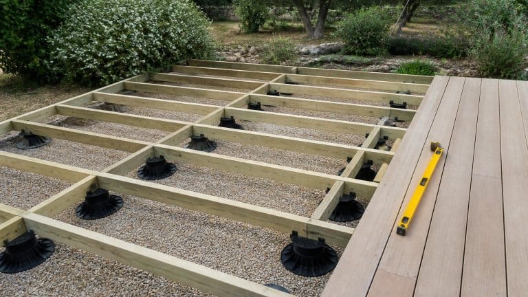 Terrasse en bois en cours de pose sur plots réglables avec lambourdes visibles