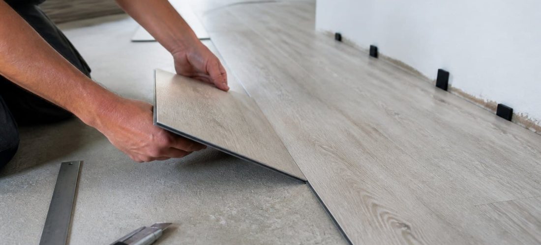 Pose de lames PVC clipsables sur un support en béton préparé, avec cale de dilatation le long du mur