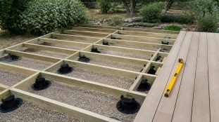 Terrasse en bois en cours de pose sur plots réglables avec lambourdes visibles
