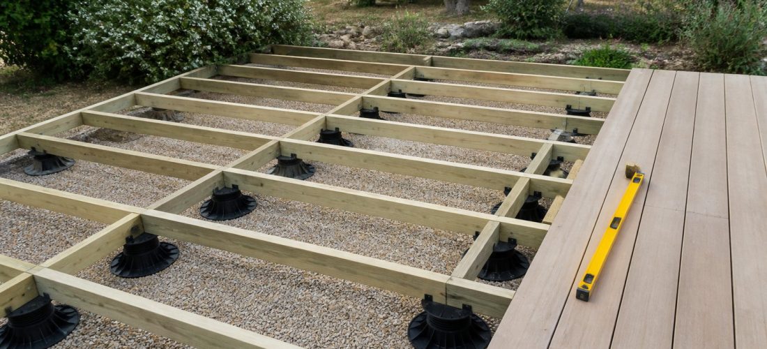 Terrasse en bois en cours de pose sur plots réglables avec lambourdes visibles
